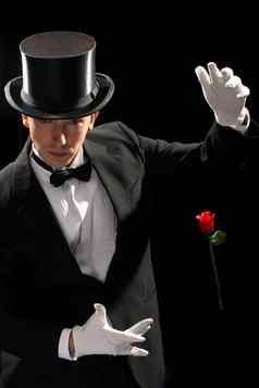 年轻的魔术师执行红色的玫瑰