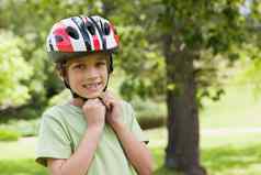 微笑男孩穿自行车头盔公园