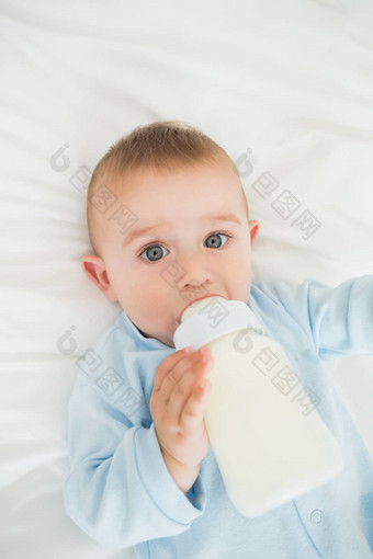 可爱的婴儿男孩喝牛奶瓶