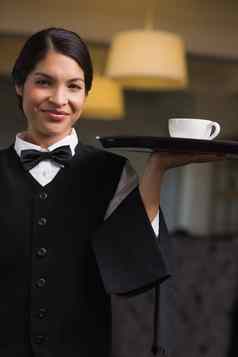 漂亮的女服务员持有托盘杯