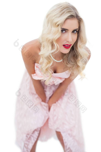 梦幻金发女郎模型粉红色的衣服摆姿势手大腿