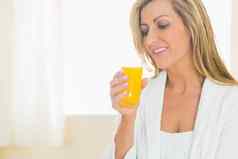 微笑女人享受玻璃橙色汁