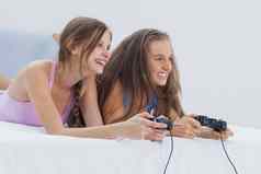 兴奋女孩玩视频游戏床上