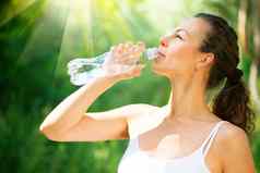 健康的运动年轻的女人喝水瓶