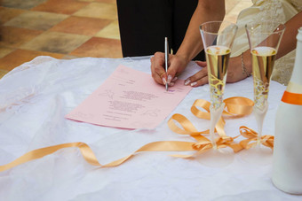 细节新娘的手迹象婚姻证书婚礼香槟眼镜户外婚礼香槟眼镜婚礼