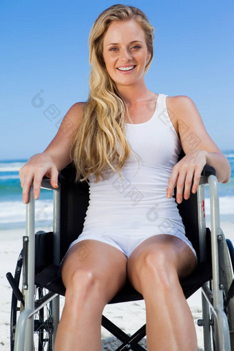 轮椅绑定金发女郎坐着海滩微笑相机