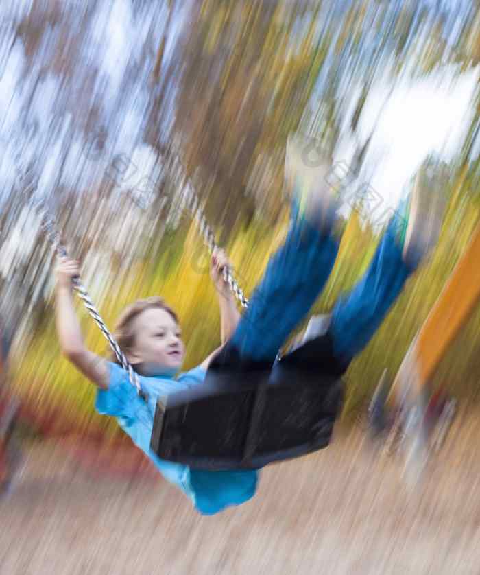 男孩摇摆不定的操场上