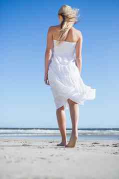 金发女郎白色衣服漫步海滩
