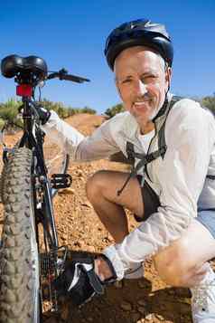 微笑骑自行车的人修复自行车链国家地形