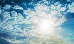 闪亮的太阳镜头耀斑蓝色的天空云背景