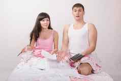 年轻的夫妇坐着床上震惊了量账户