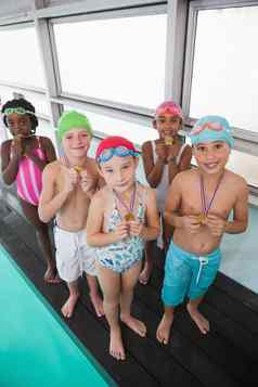 可爱的孩子们站在游泳池边奖牌