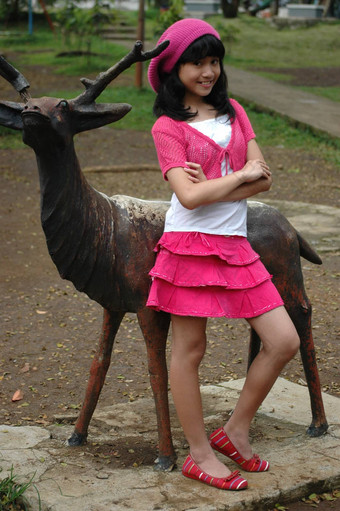 可爱的女孩站鹿雕像