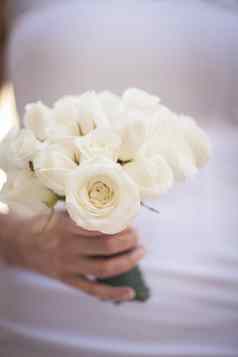 新娘白色婚礼衣服持有花束玫瑰花