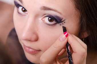 化妆艺术家油漆点箭头女孩的眼睛