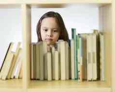 年轻的女孩书书架上
