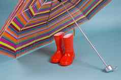 红色的孩子们雨靴子色彩斑斓的伞