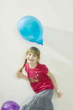 年轻的快乐女孩玩颜色气球