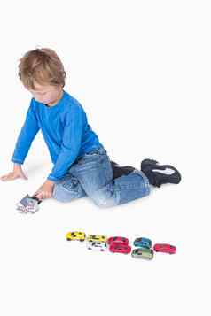 年轻的男孩玩剧场玩具汽车