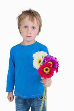 肖像可爱的年轻的男孩持有花