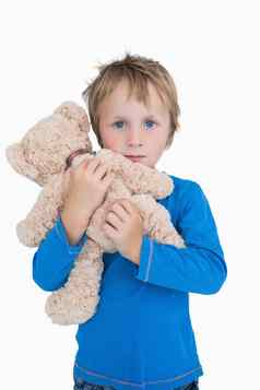 肖像可爱的年轻的男孩拥抱泰迪熊