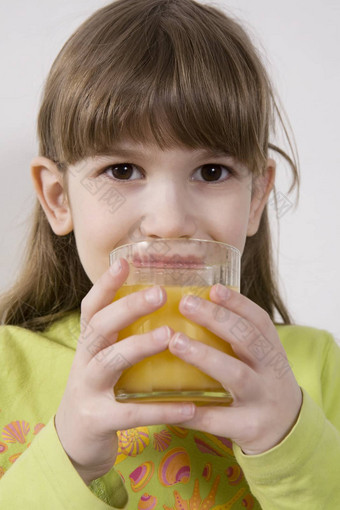 可爱的可爱的女孩年喝橙色汁