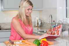 女人阅读食谱书切割蔬菜厨房