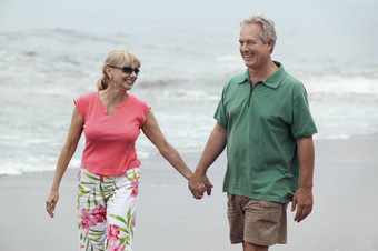 夫妇持有手走海滩
