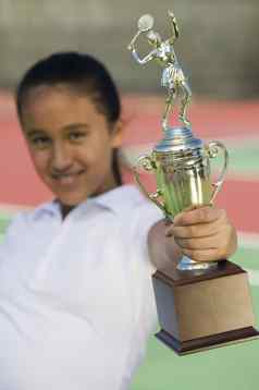 年轻的女孩网球法院持有奖杯焦点奖杯