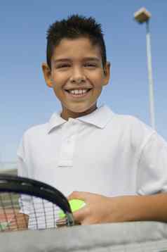 年轻的男孩网球球拍球网网球法院肖像关闭