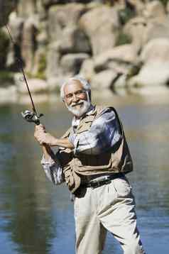肖像快乐拉美裔高级男人。钓鱼阳光明媚的一天
