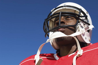 特写镜头低角视图美国足球球员穿头盔清晰的蓝色的天空