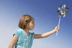 女孩玩纸风车玩具清晰的天空