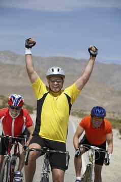 健康的高级男人。庆祝胜利竞争对手骑自行车背景