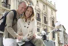肖像快乐中间岁的夫妇踏板车阅读地图前面建筑