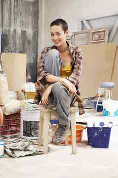 肖像年轻的女画家坐着凳子工作网站