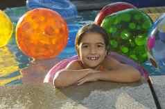 肖像可爱的女孩浮动环海滩球游泳池