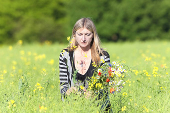 女人挑选野生花草地