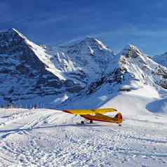 黄色的飞机瑞士冬天山滑雪度假胜地