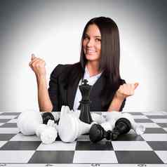 快乐的女商人赢了国际象棋提高了手