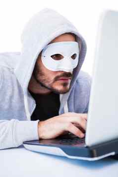 男人。穿面具黑客移动PC