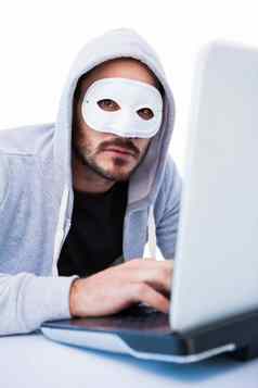 男人。穿面具黑客移动PC