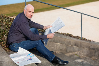 男人。坐着步骤阅读报纸