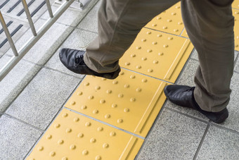男人。腿穿越黄色的行火车站