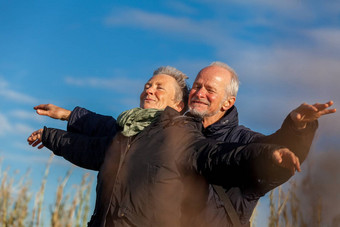 上了年纪的夫妇拥抱庆祝太阳