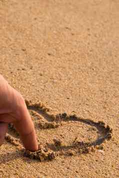 手指吸引了爱心沙子