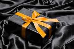 黑色的礼物盒子黄色的缎丝带弓