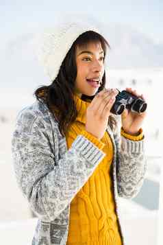 微笑女人穿冬天衣服双筒望远镜
