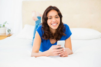 微笑女人智能手机说谎床上
