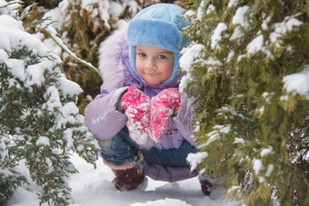 女孩隐藏白雪覆盖的fur-trees
